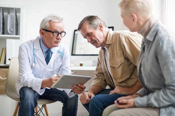 istock Serious senior male doctor in white coat using digital tablet while analyzing tests results of aged patients after medical checkups 1194338535