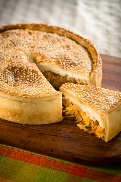 Sliced salty pie with a crispy golden-brown crust Sliced chicken salty pie with a crispy golden-brown crust and white sesame, ready to eat, on a blue napkin palm heart photos stock pictures, royalty-free photos & images