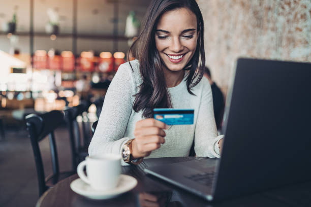 istock Smiling woman making a credit card purchase 1194340260