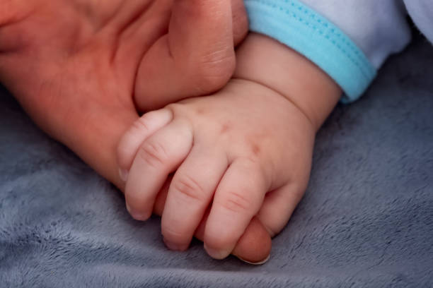 istock Baby hand holding mother's finger 1194340290