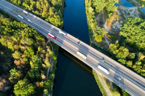 Trucks and cars on highway bridge over river, aerial view, Baden Wurttemberg, Germany.