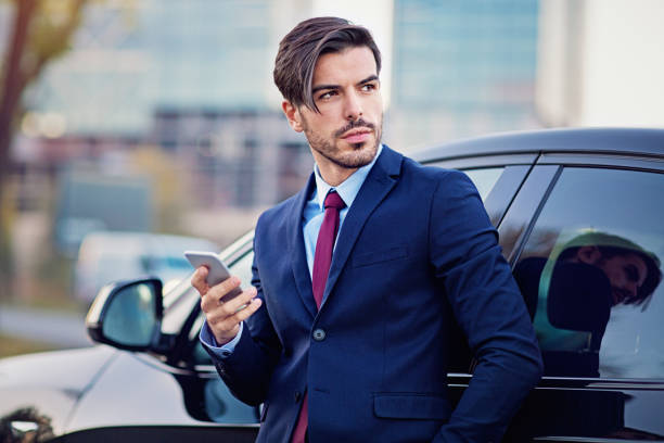 istock Businessman is texting next to his car 1194340513
