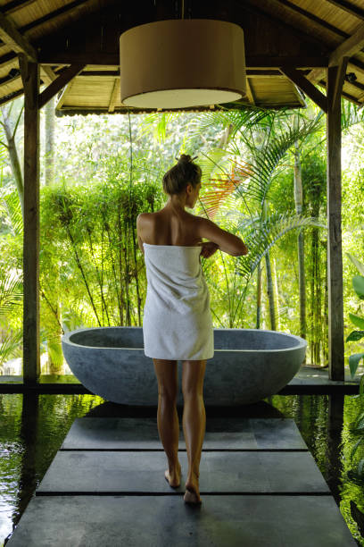 istock Woman in open air bathroom with stone bath 1194351322