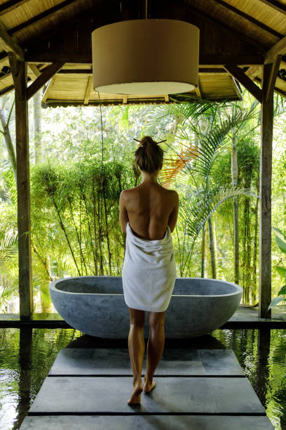istock Woman in open air bathroom with stone bath 1194351331