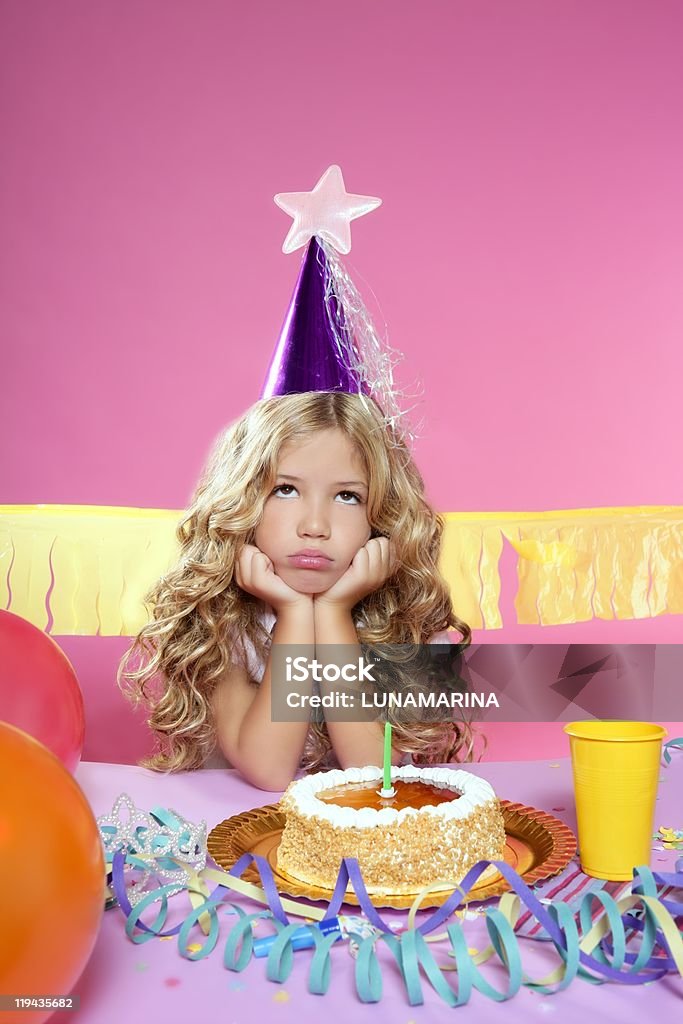 Annoiato piccola ragazza bionda mette in festa di compleanno dolce con candele - Foto stock royalty-free di Bambino