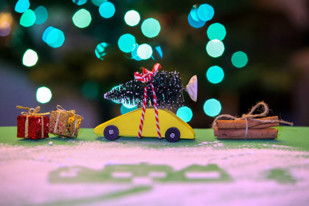 istock Yellow car with Christmas tree, decoration and lights in background 1194358089