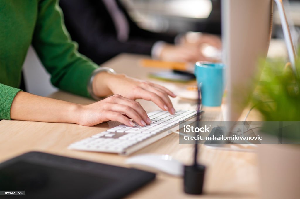 Getting down to work Close-up shot of a woman typing on a keyboard Travel Agency Stock Photo