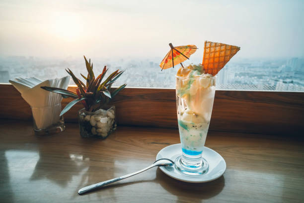 Cocktail on an aged wooden deck. Ice cream blue lagoon in the restaurant on the background of a beautiful sunset in the city