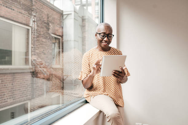 Smiling senior woman reading newspaper