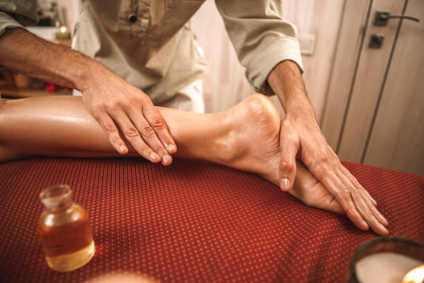 альтернативная медицина. терапевт исцеления женщина делает abhyanga массаж с маслом на ногах крупным планом - chakra ayurveda recovery herbal medicine стоковые фото и изображения