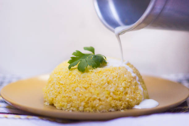 cuscuz - traditional dish from northeastern brazil. cuscuz can be made from flour, corn, rice or cassava. milk being poured into couscous - baking flour ingredient animal egg imagens e fotografias de stock