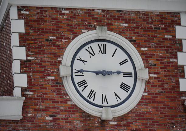 istock Round Roman clock mounted on a red brick wall 1194380937