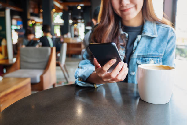 istock a woman holding, using and looking at mobile phone 1194390323