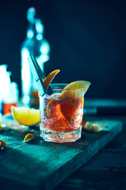 Alcoholic cocktail with orange peel and ice.