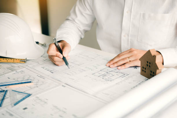 istock Architects working with blueprints and discussing project together at the meeting in the office. 1194393845