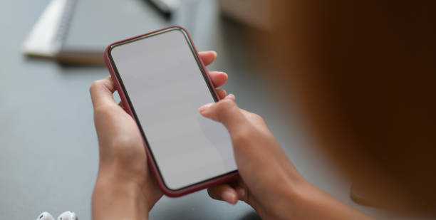 istock Cropped shot young businesswoman holding blank screen smartphone while working 1194395086