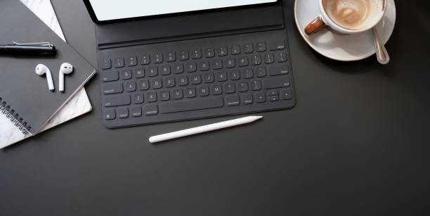 istock Top view of stylish workplace with digital tablet and coffee cup on black table 1194395093