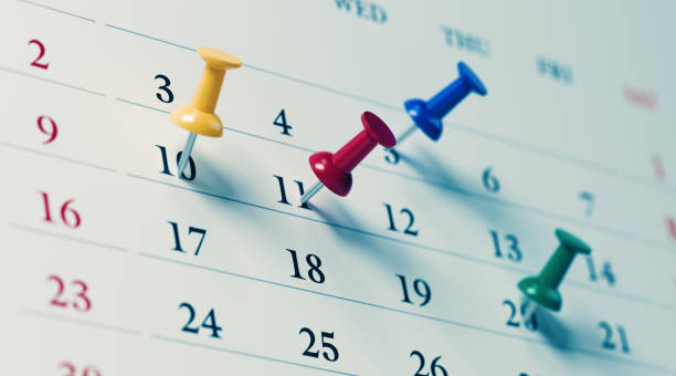 White calendar with colored push pins reminding important dates. Calendar and reminder concept. Horizontal composition with copy space.