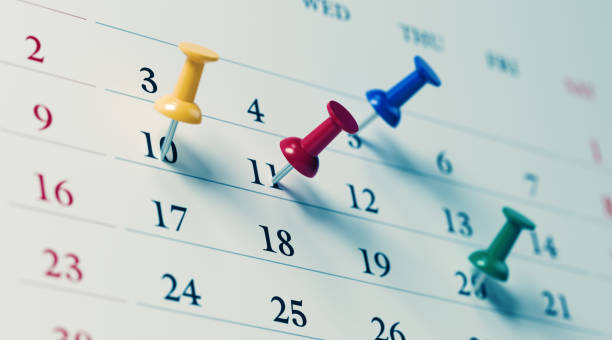 calendario bianco con pin push colorati che mostrano date importanti - calendario foto e immagini stock