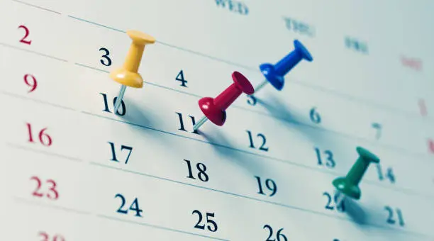 Photo of White Calendar With Colored Push Pins Showing Important Dates