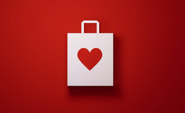 weiße einkaufstasche mit herzform auf rotem hintergrund - heart shape christmas paper christmas gift stock-fotos und bilder
