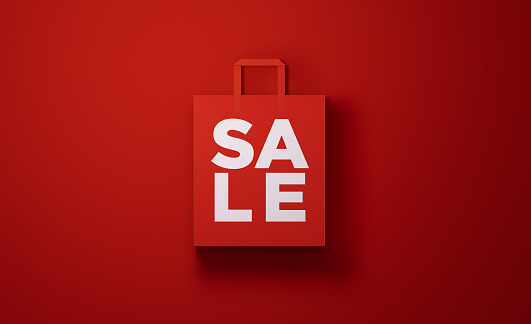 Red shopping bag with sale text on red background. Horizontal composition with copy space, Great use for sale concepts.