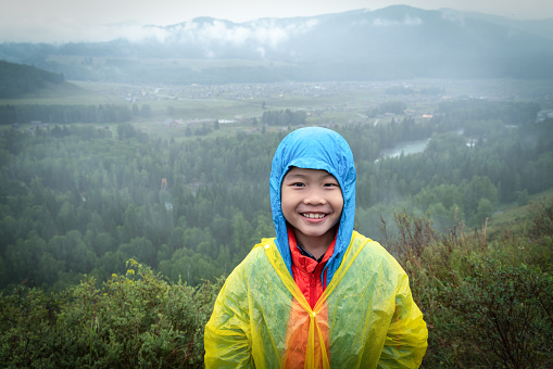 Young boy looking at camera in rain day