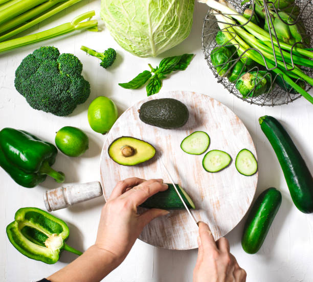 istock Top view woman's hands who cuts fresh green vegetables. 1194399386