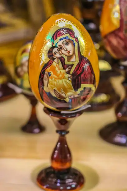 Traditional Russian Palekh religious lacquer Easter egg with gold leaf depicting Virgin Mary and Jesus in a souvenir shop in Saint Petersburg, Russia
