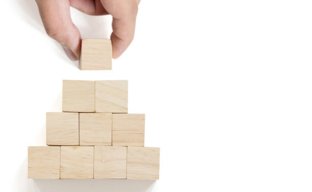 istock Hand arranging wood block stacking on top pyramid with white background. Business concept for growth success process 1194407057