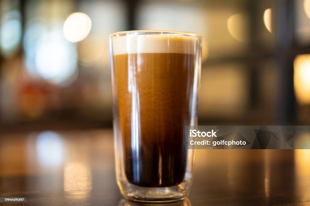 Cold brew coffee. Beautiful texture and layers of Nitro Cold Coffee served in a double wall glass close up. Nitrogen Stock Photo