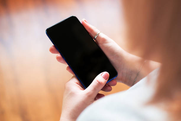 istock girl holding a mobile phone with a blank display mockup selective focus 1194413456