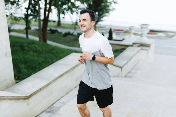istock A cheerful young man is running in park. 1194415329