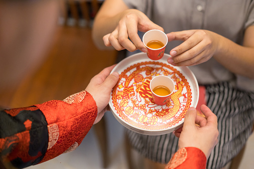 Newlywed serving tea to elder on Chinese traditional tea ceremony