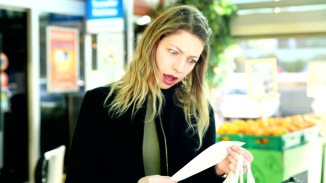 Woman Checking Shopping Bills at the Supermarket - 4K Resolution
