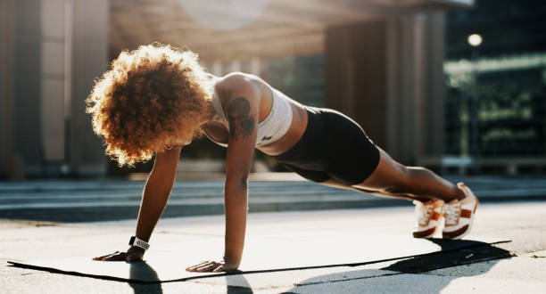 I'm doing all for a better me Shot of an beautiful young female athlete working out in the city push ups stock pictures, royalty-free photos & images