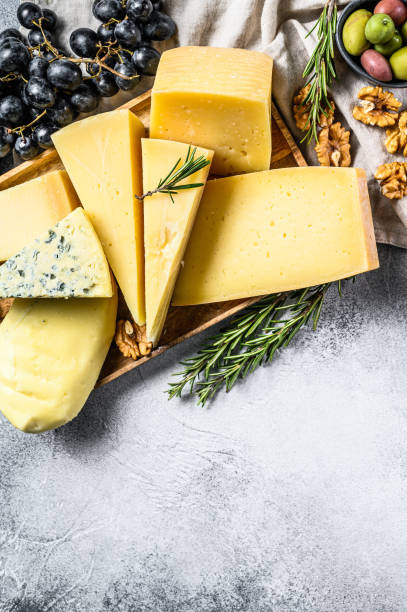 istock Cheese plate served with grapes, crackers, olives and nuts. Assorted delicious snacks. Gray background. Top view. Space for text 1194425489
