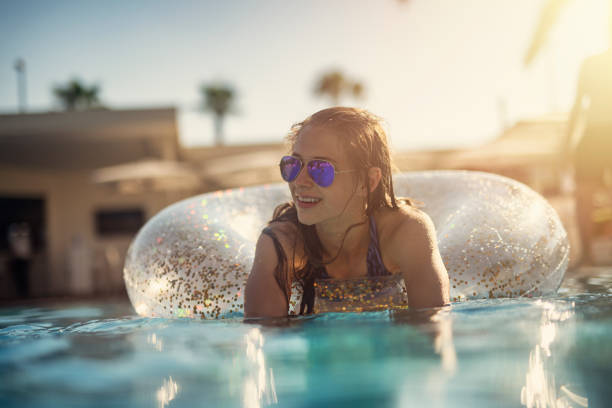 adolescente appréciant la piscine - floatation device flash photos et images de collection