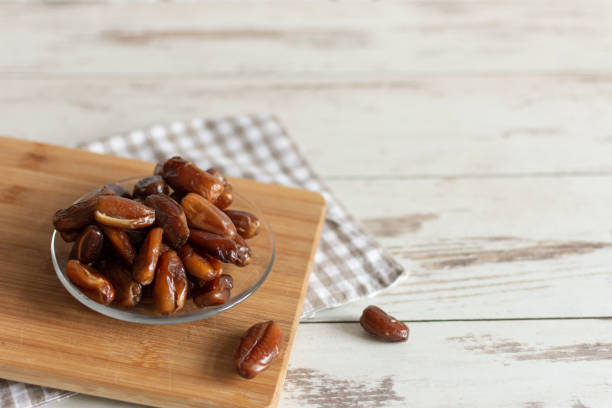 istock Bowl of dried dates on wooden background with space for text. 1194428355
