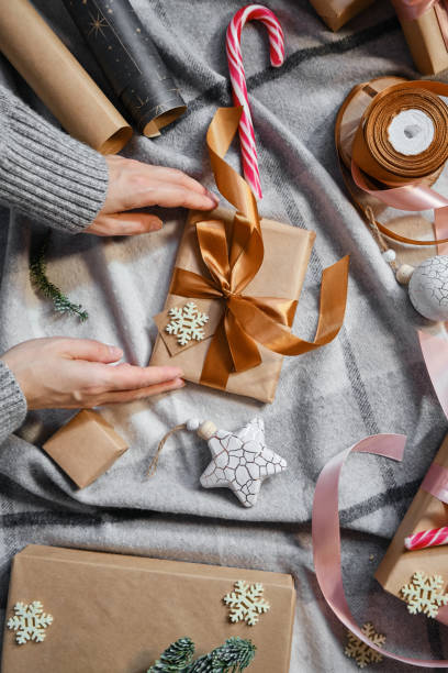 Woman holds a Christmas present in hands. Happy holiday, gift box close-up. Surprise for Boxing day, Christmas and New Year party. Magic time. Celebration winter event. Wrapping paper, toys and ribbon la mujer tiene un regalo de navidad en las manos. feliz fiesta, caja de regalo de primer plano. sorpresa para el día del boxeo, navidad y fiesta de año nuevo. tiempo mágico. evento de invierno de celebración. papel de envoltorio, juguetes y cinta
