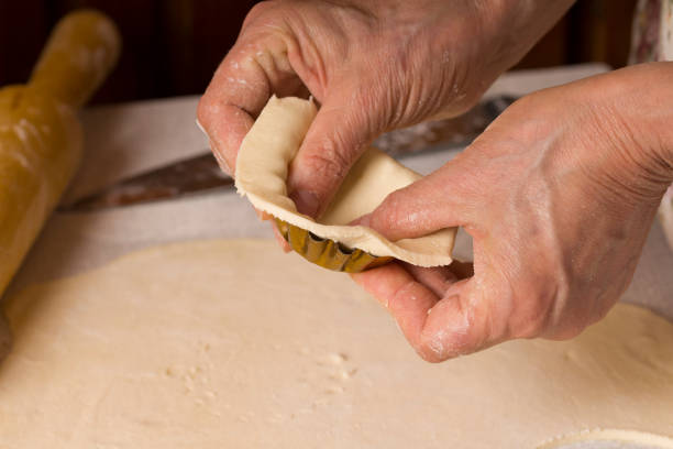 Cooking Process Of Tartlets. Close up hands cooking homemade on kitchen table