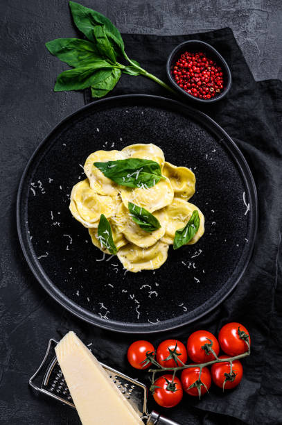 istock Italian ravioli pasta with cheese and Basil. Black background. Top view 1194430551