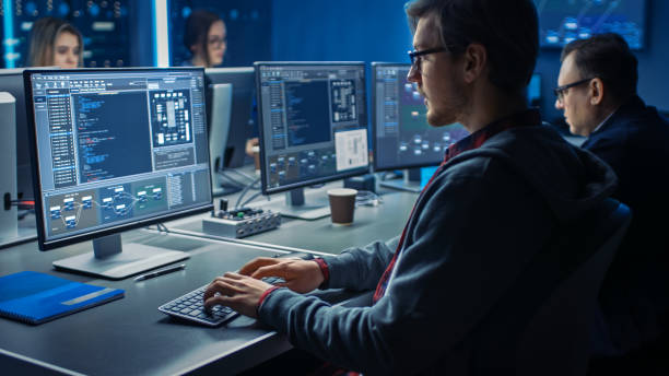 Smart Male IT Programer Working on Desktop Green Mock-up Screen Computer in Data Center System Control Room. Team of Young Professionals Programming Sophisticated Code Smart Male IT Programer Working on Desktop Green Mock-up Screen Computer in Data Center System Control Room. Team of Young Professionals Programming Sophisticated Code Information Security Engineer stock pictures, royalty-free photos & images