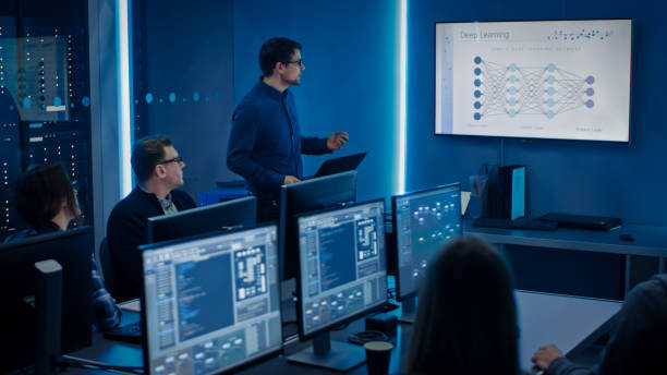 istock Team of Professional IT Developers Have a Meeting, Speaker Talks about New Blockchain Based Software Development Shown on TV. Concept: Deep Learning, Artificial Intelligence, Data Mining, Neural Network 1194430854