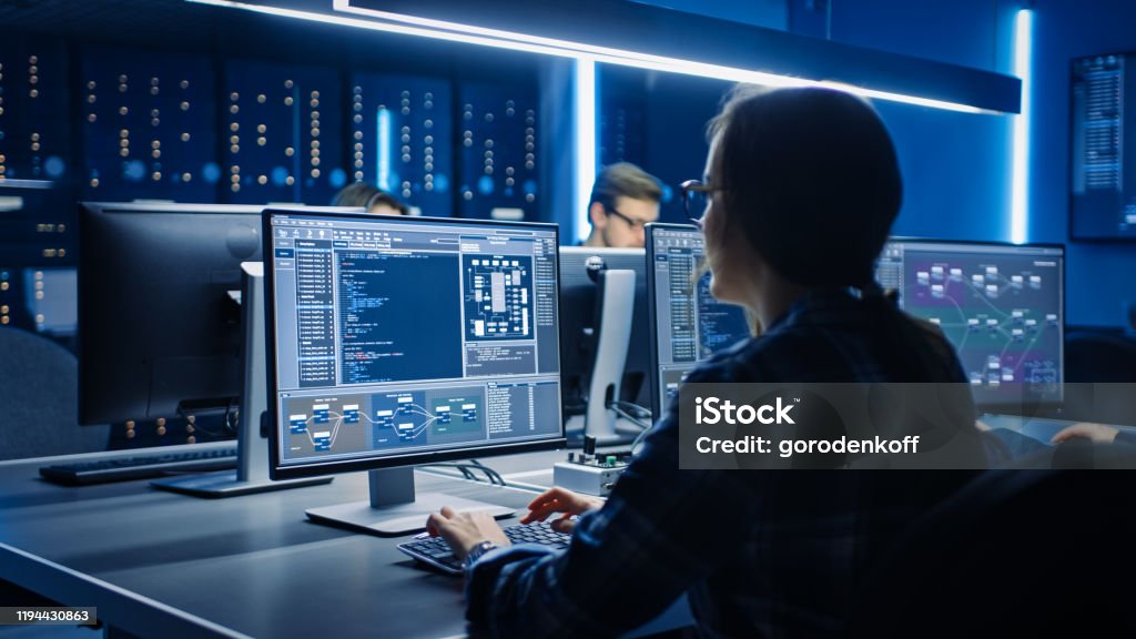 Smart Female IT Programer Arbeiten auf Desktop-Computern im Data Center System Control Room. Team von Young Professionals doing Code Programming - Lizenzfrei Technologie Stock-Foto Smart Female IT Programer Arbeiten auf Desktop-Computern im Data Center System Control Room. Team von Young Professionals doing Code Programming - Lizenzfrei Technologie Stock-Foto