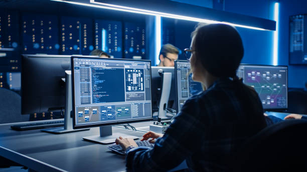 smart female it programer arbeiten auf desktop-computern im data center system control room. team von young professionals doing code programming - software stock-fotos und bilder