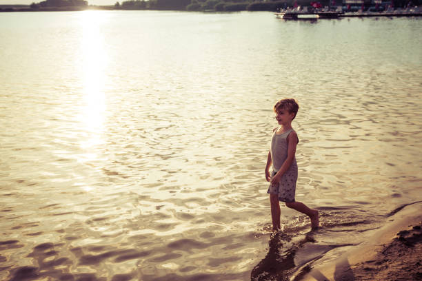 istock Happy small boy on the beach at sunset. 1194431972