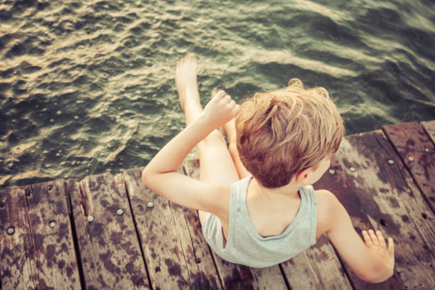 istock Above view of boy on a pier during summer day. 1194432272