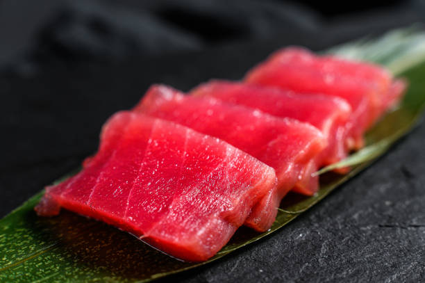 istock sashimi tuna on a stone Board. Black background. Top view. Close up 1194435777