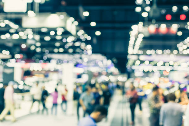 Blur event hall in large exhibition center with people walking background people Blur event hall in large exhibition center with people walking background people tradeshow photos stock pictures, royalty-free photos & images